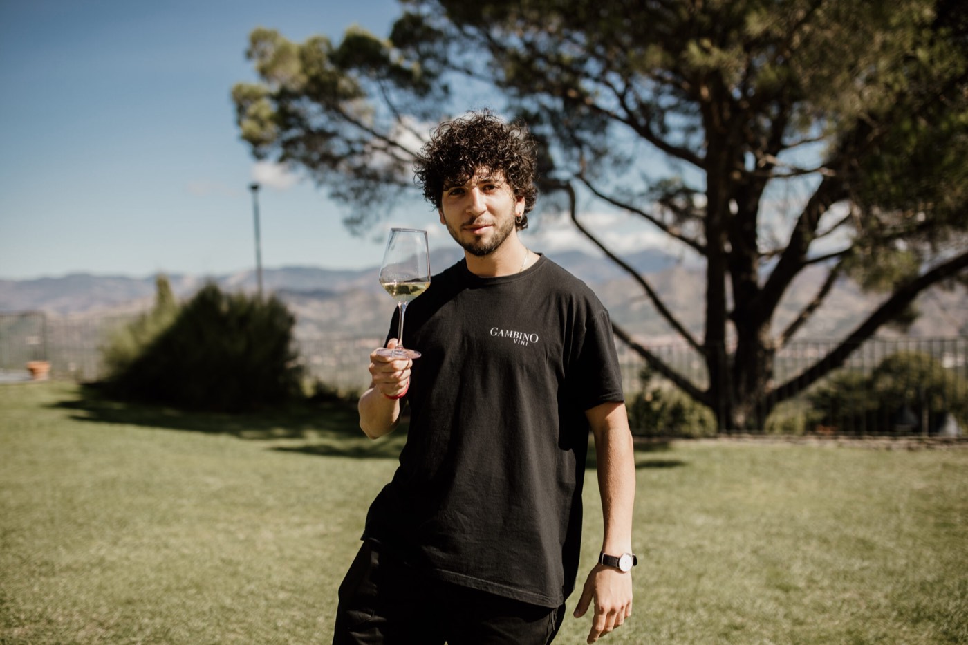 Un membro del team con un calice nel giardino della cantina