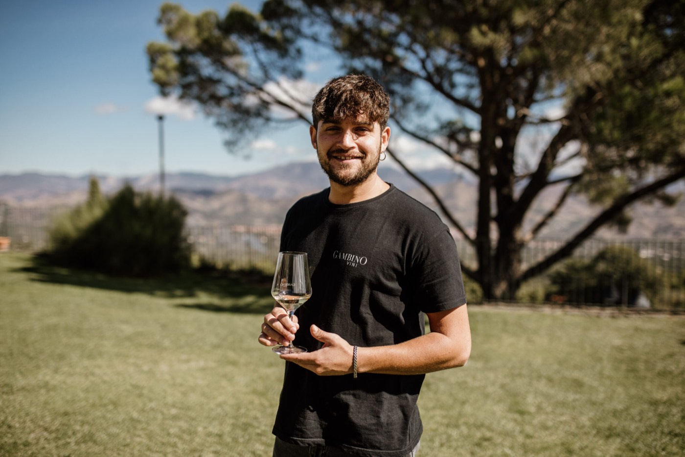 Un sommelier con un calice di vino bianco